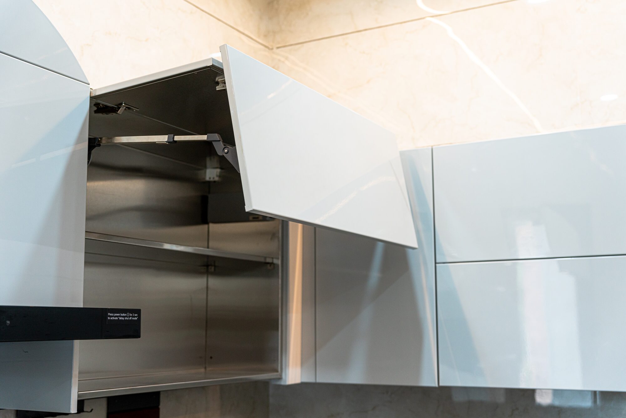 Close-up of stainless steel cabinet construction and soft-close hinge